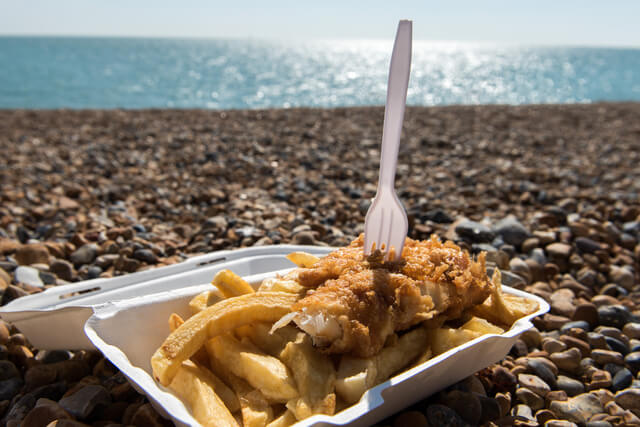 A portion of takeaway fish and chips by the shoreline