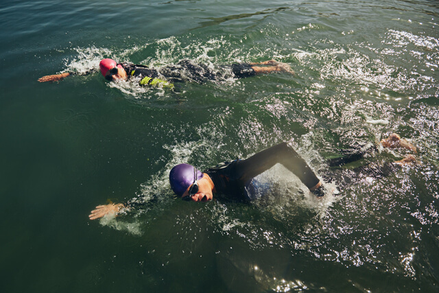 Three people swimming together in open water